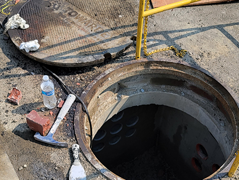 Newly replaced and relocated HEX manhole C19BA-203.  The project interface consisting of (11) 4 inch ducts and (4) 1.25 inch ducts arriving from C19BA Tranche 1 section are visible, with the new 'cast in place' replacement wall completed during the previous day.
