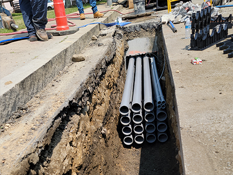 Crews are installing southbound (15) 4 inch ducts and (4) 1.25 inch ducts at manhole C19BA-203 for the mainline trench.